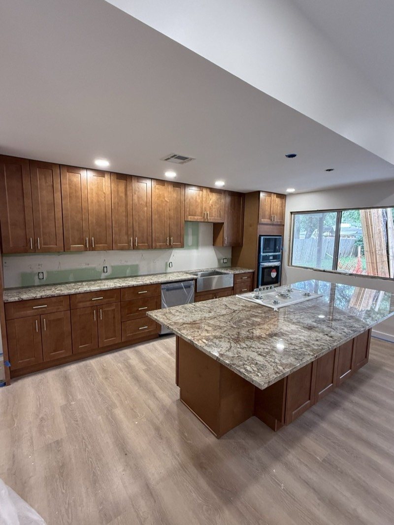 Open-plan maple kitchen with a large granite island in San Antonio