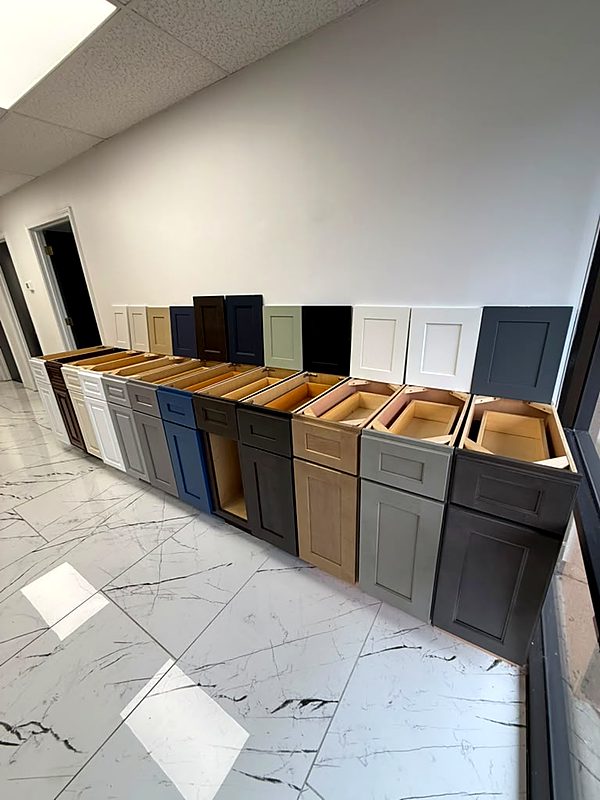 A row of sample base cabinets in different finishes, side by side