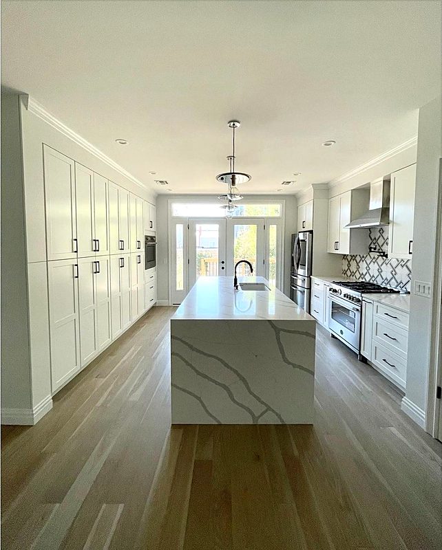 White galley kitchen with a waterfall island in San Antonio